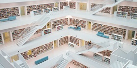 Multilevel library with many books, white floors and shelves, seating areas, and a staircase.