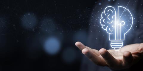Hand with a light bulb that is partly shaped like a brain