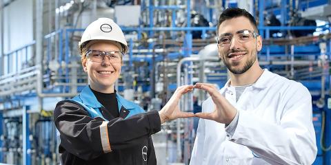 Two Covestro employees form a circle with their hands.